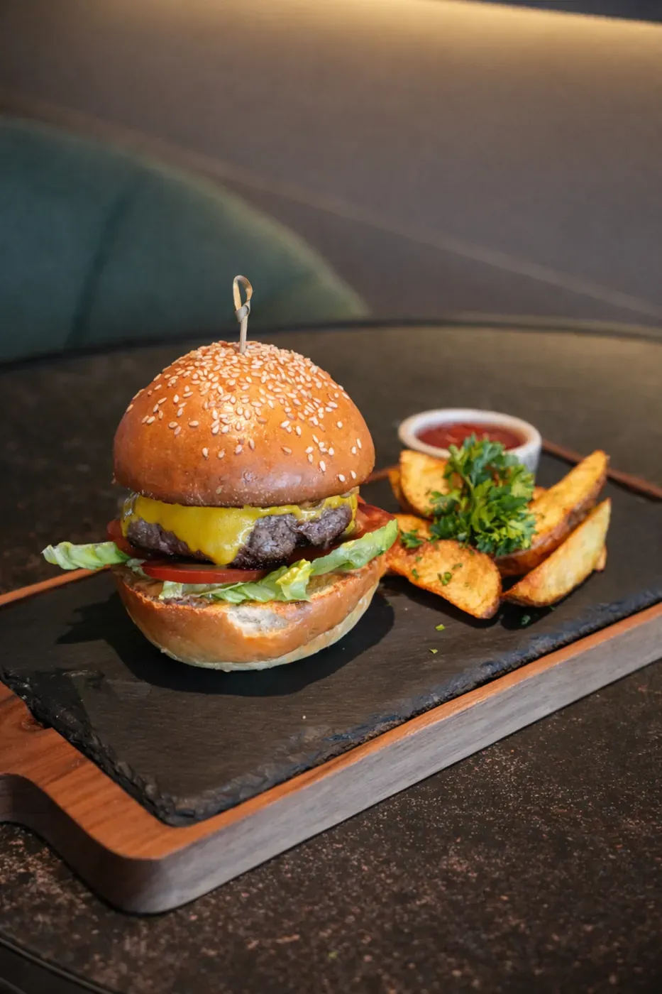 Gourmet beef burger with potato wedges and dipping sauce