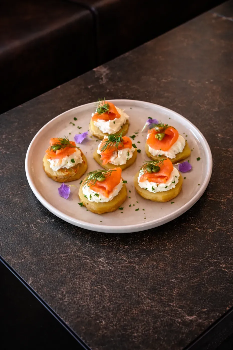 Smoked salmon blinis topped with edible flowers