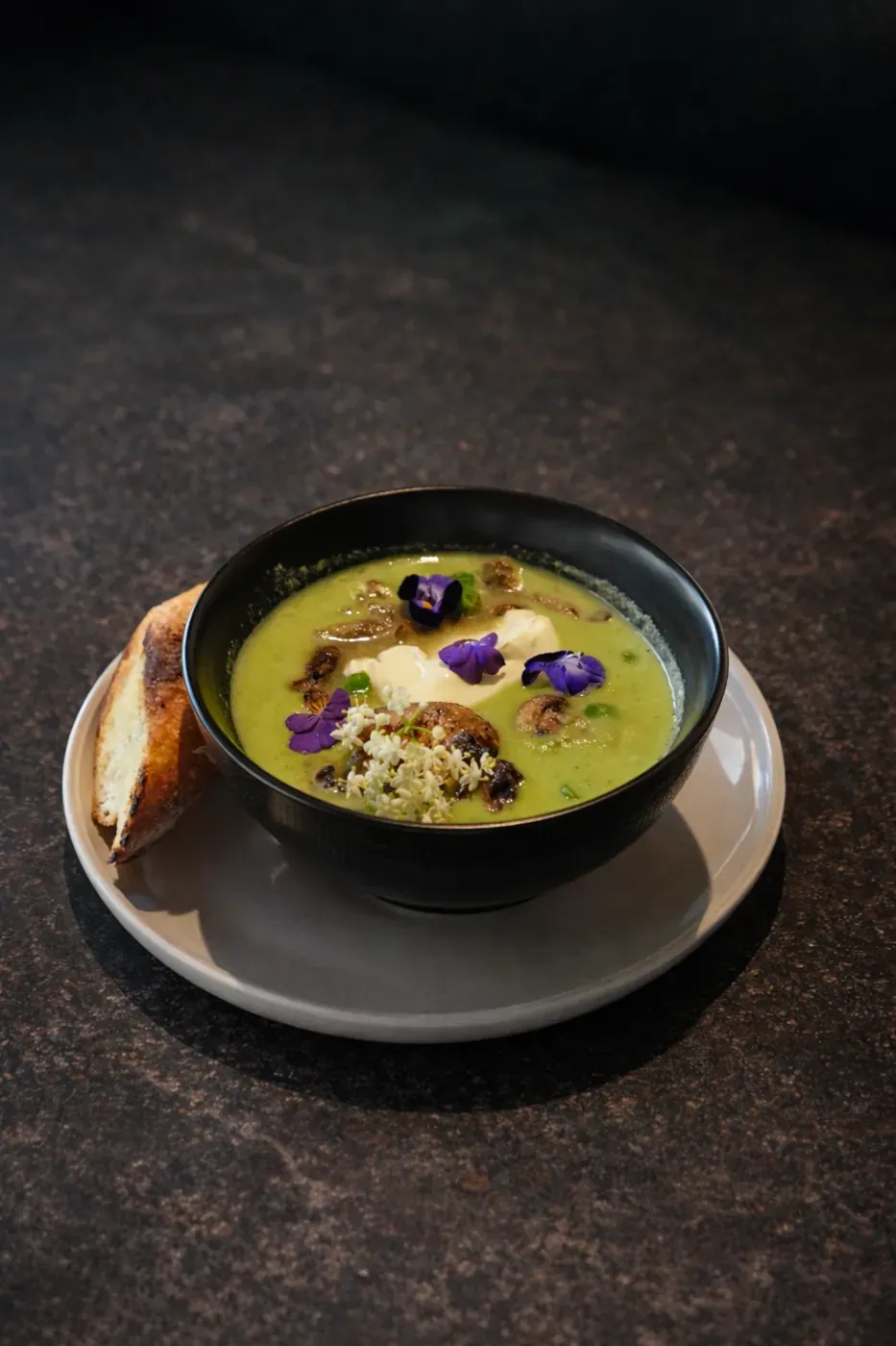Green pea and mushroom soup in a dark bowl