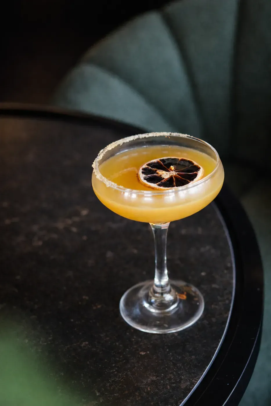 Whiskey sour cocktail in a coupe with dried citrus