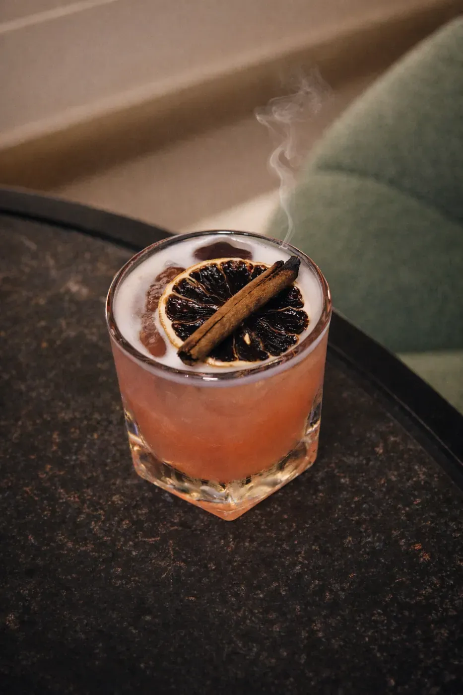 Old fashioned cocktail with cinnamon and dried orange