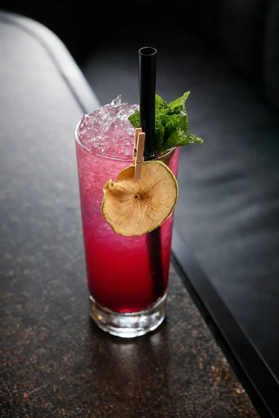 Red berry cocktail with a dried apple garnish