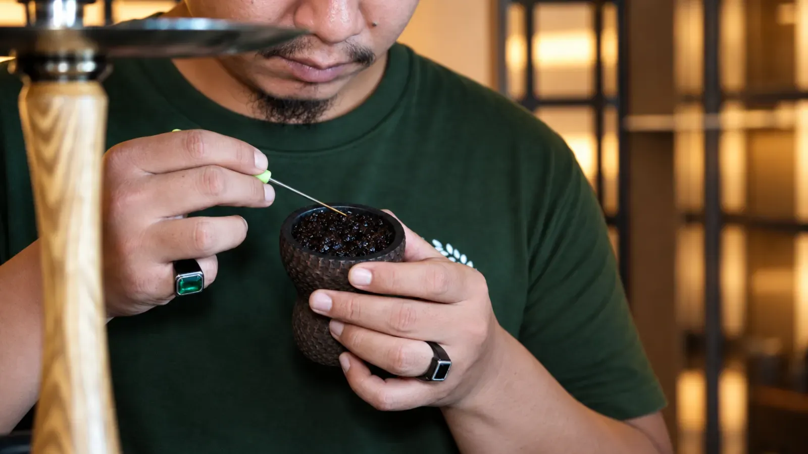 Shisha master packing tobacco into a clay bowl at Maison Almaz, Canggu