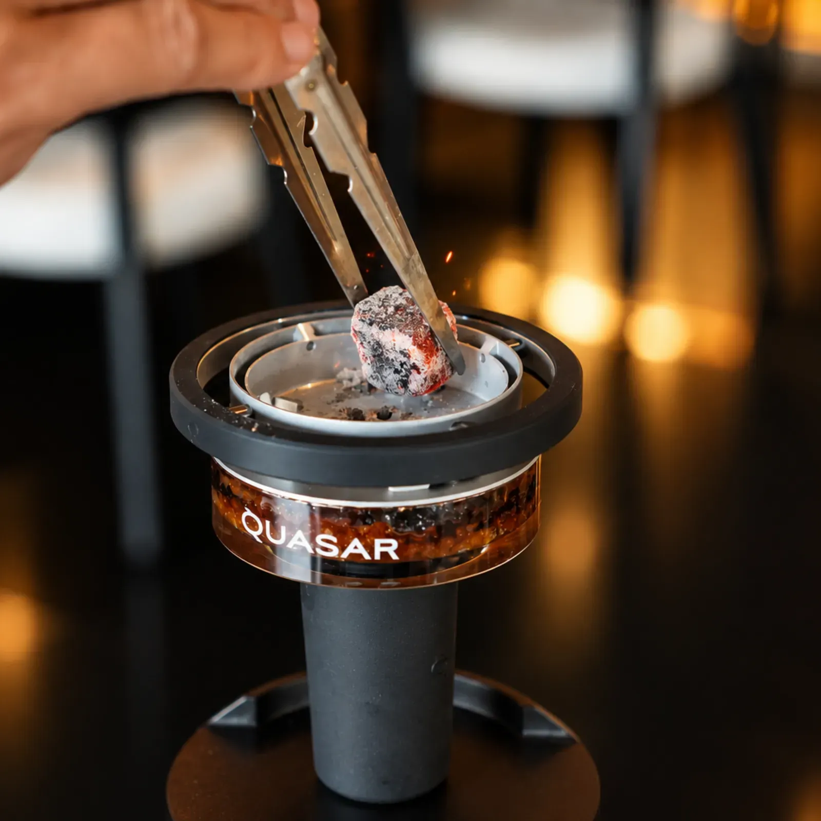 Shisha master adjusting coals in a Quasar Raas 2 head at Maison Almaz, Canggu
