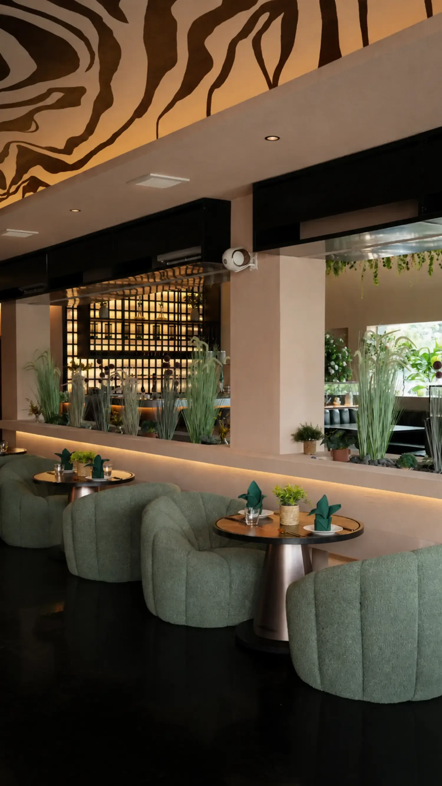Green velvet lounge seating beside the garden at Maison Almaz, Canggu